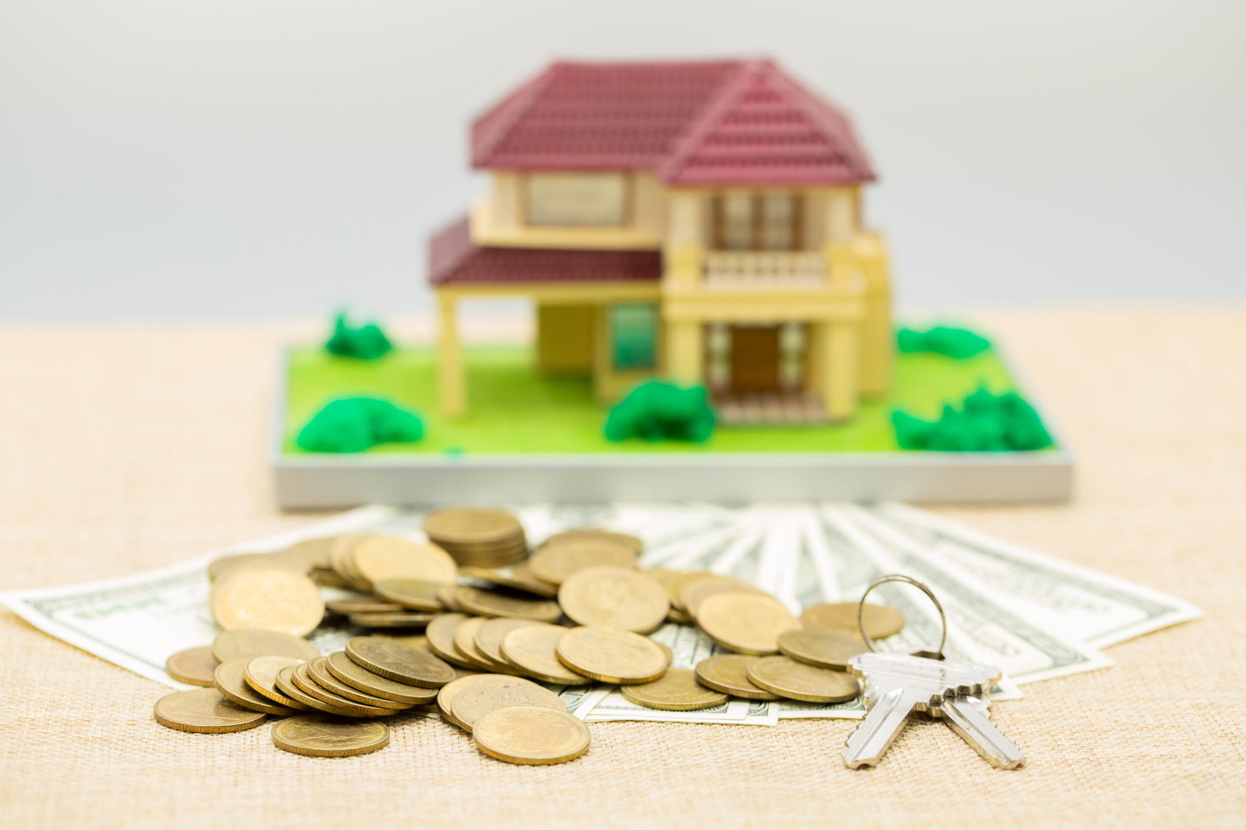 House placed on coins. notebook and pen Prepare planning savings money of coins to buy a home concept.